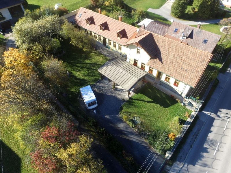 Letecký pohľad na dom so záhradou a rekreačnými bytmi v zadnej časti.
