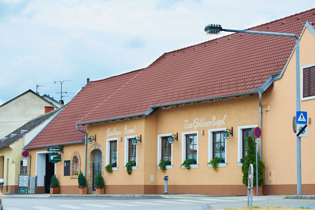 Tradičný hostinec so žltou fasádou a červenou strechou s označením "Gasthaus Rammel" a "Zum Goldenen Engel".