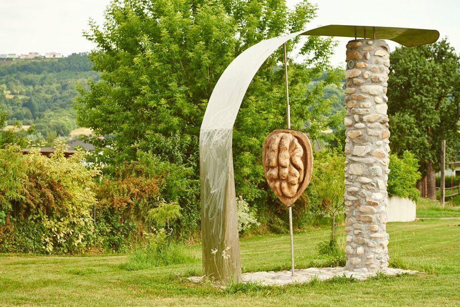 Socha orecha v Krummnußbaum, obklopená stromami a lúkou.