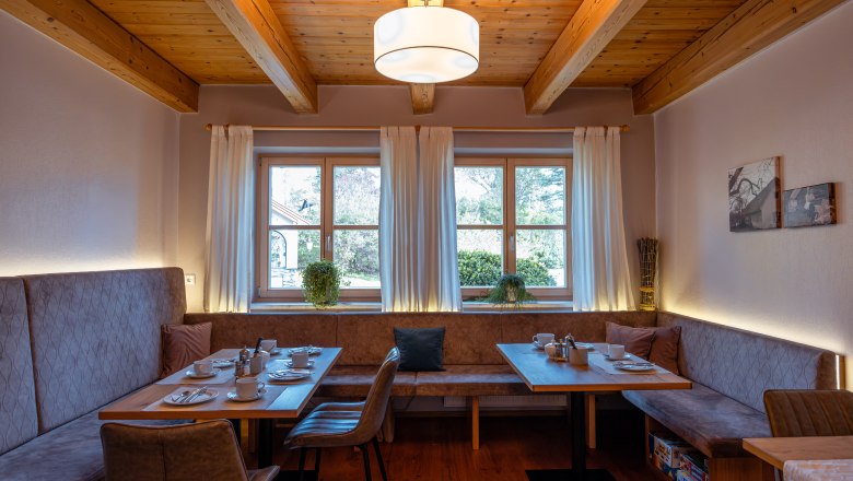 &Uacute;tuln&aacute; jed&aacute;leň s dreven&yacute;m tr&aacute;mov&yacute;m stropom, oknom a prestret&yacute;m stolom.