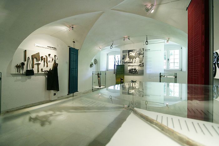 Pohľad do interiéru múzea s nástrojmi a historickými fotografiami.