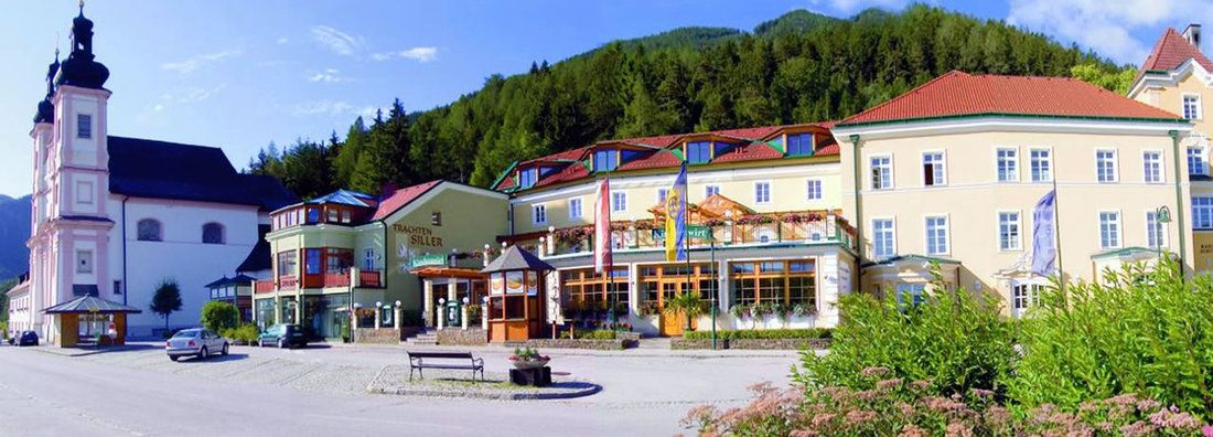 Exteriérový pohľad na tradičný hostinec vedľa kostola v horskej krajine.