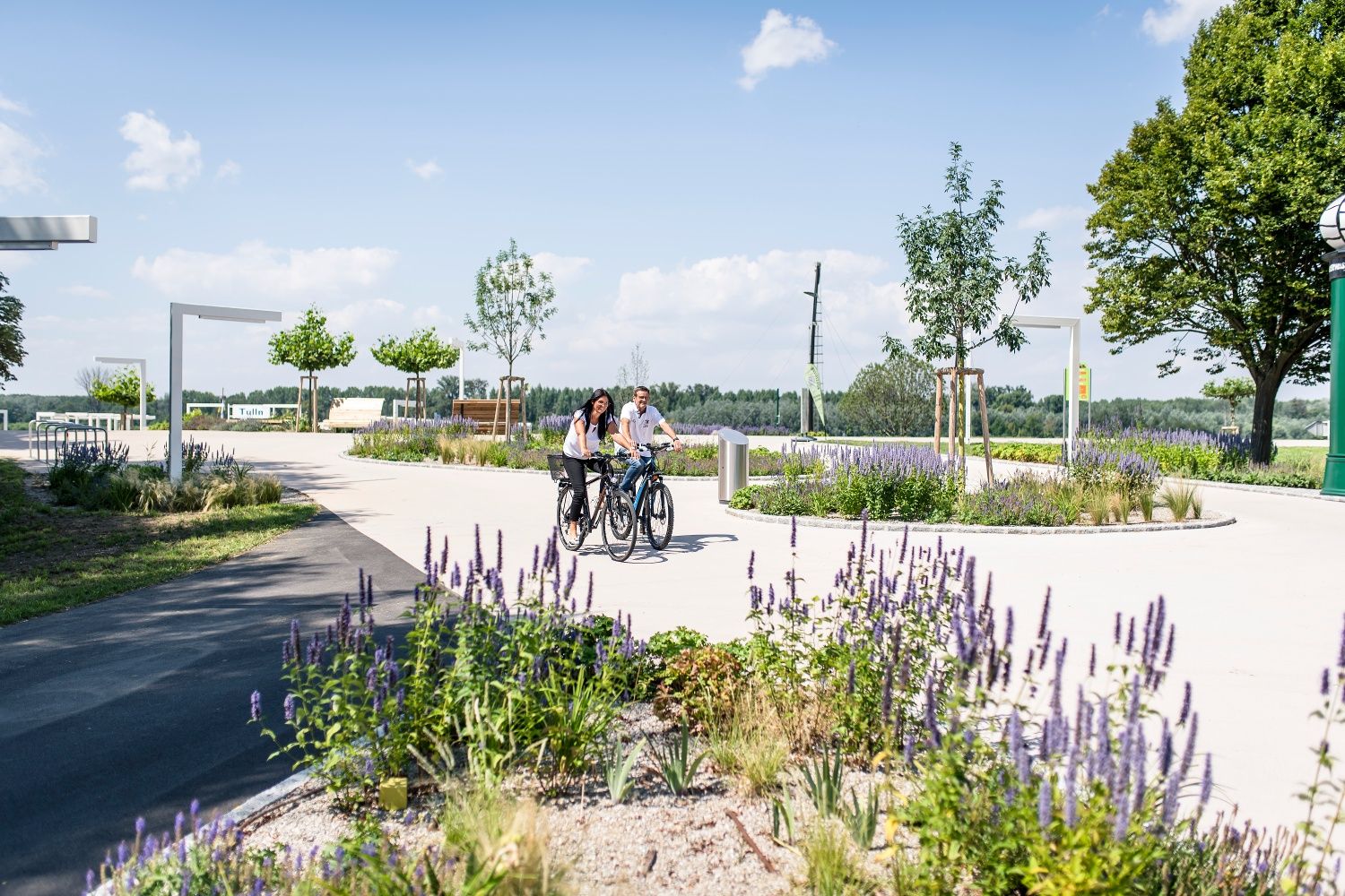 Dvaja ľudia jazdia na bicykloch cez rozkvitnutý park v Tulln an der Donau.