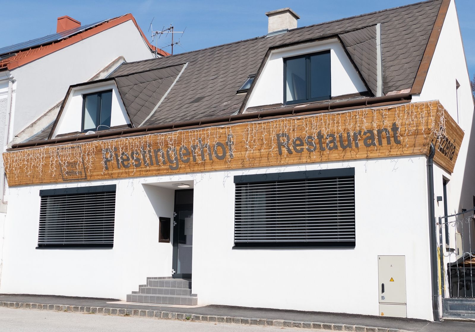Fasáda reštaurácie Piestingerhof zdobená rozprávkovými svetlami.