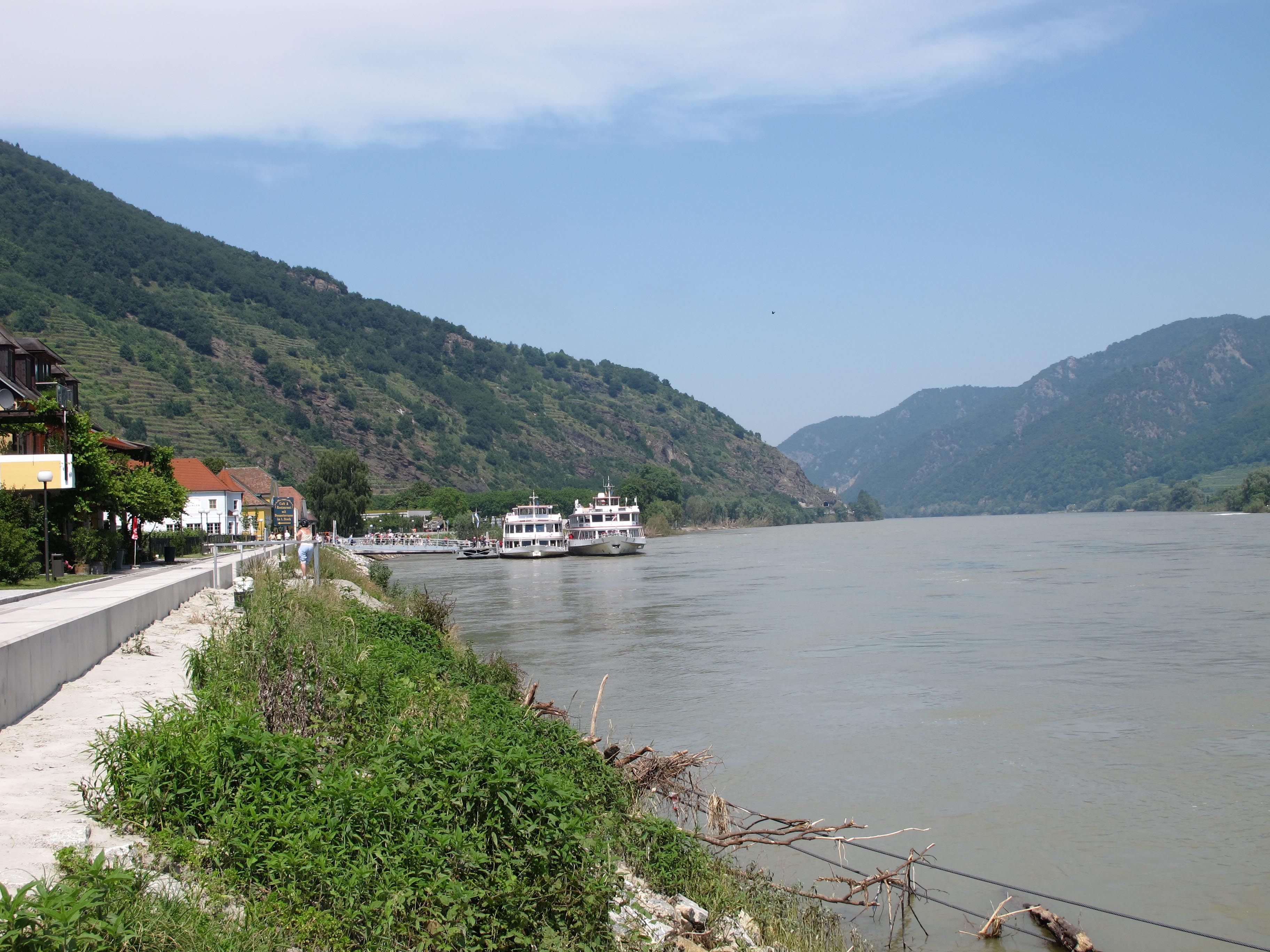 Prístavisko v meste Spitz na Dunaji s loďami a kopcami v pozadí.