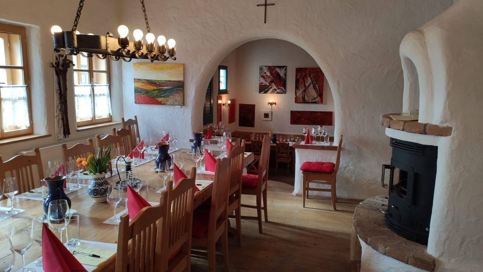 Útulná izba s prestretým stolom, pohármi na víno a krbom.