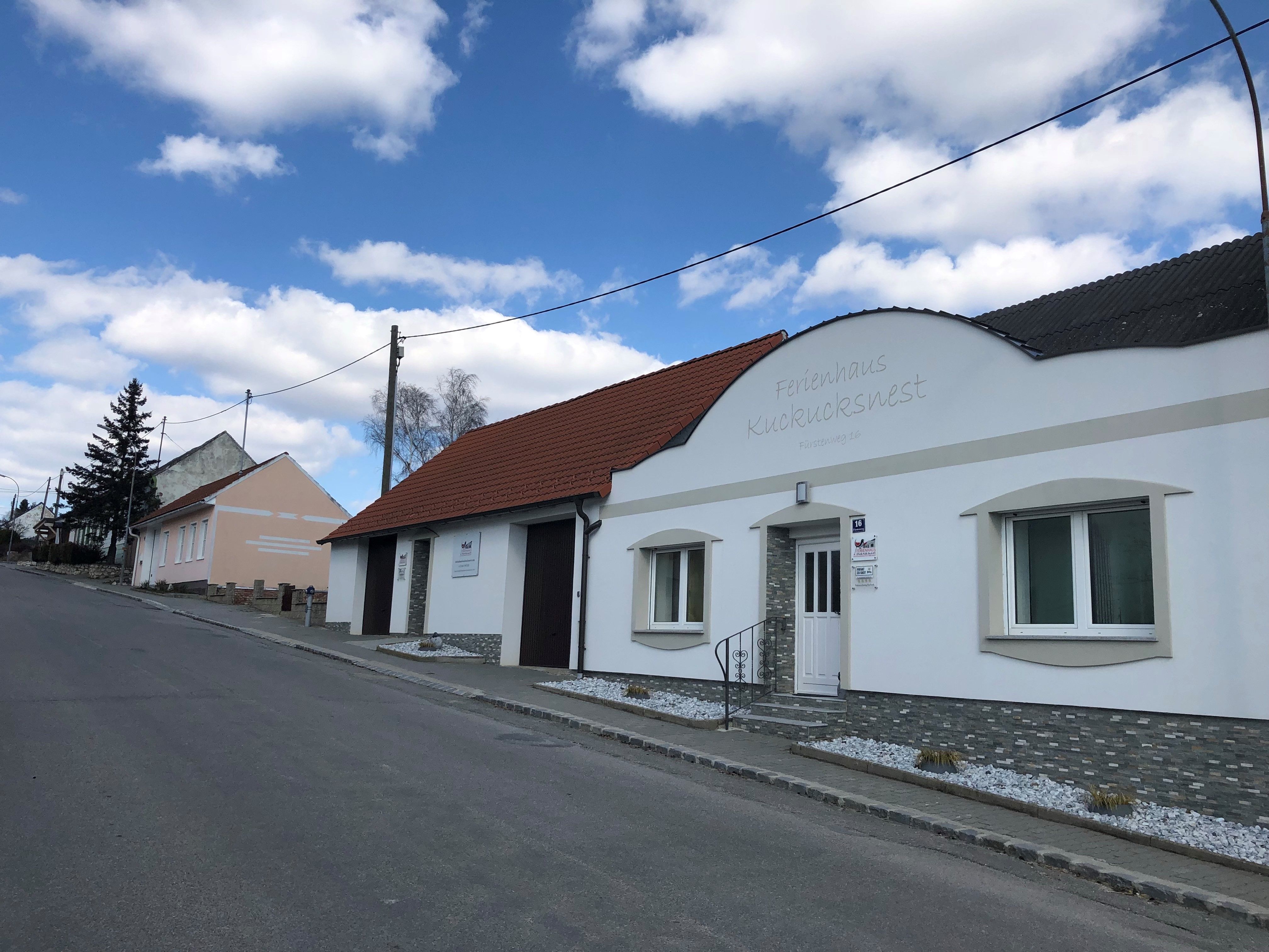 Ulica s rekreačným domom Kuckucksnest a modrou oblohou.