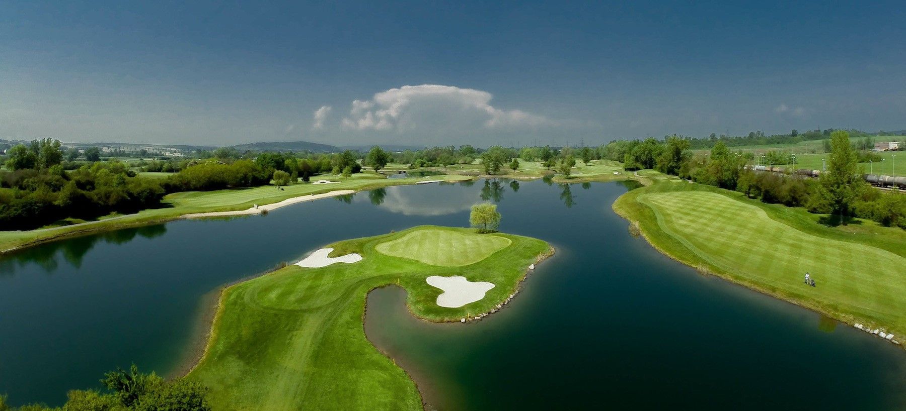 Pohľad na golfové ihrisko s rozsiahlym jazerom.