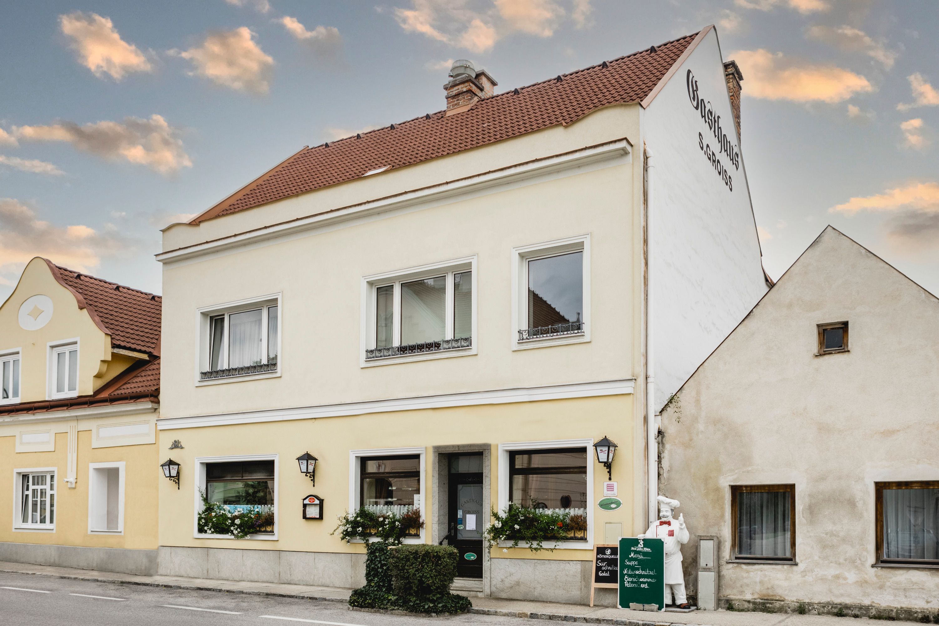 Žltý hostinec s nápismi a kvetmi v Berndorfe.