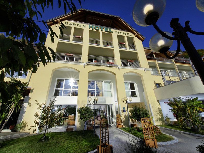 Exteriérový pohľad na Gartenhotel Pfeffel so žltou fasádou a balkónmi.