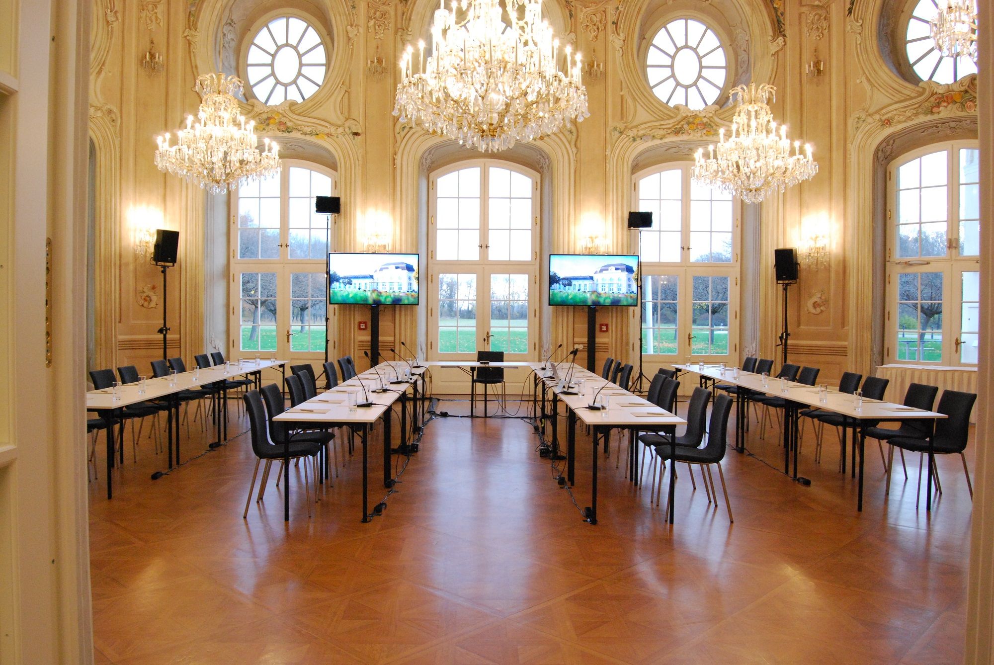 Elegantná konferenčná miestnosť s lustrami a veľkými oknami.