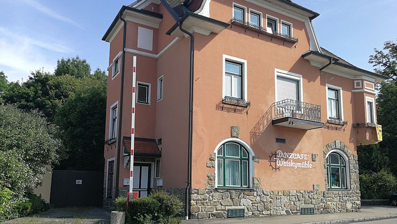 Dvojpodlažná budova s označením "Tanzcafé Whiskymühle".