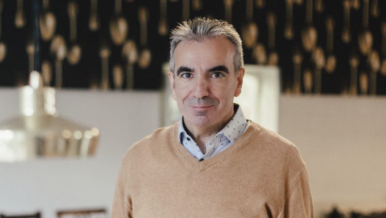 Muž v re&scaron;taur&aacute;cii drž&iacute; v ruke tanier s jedlom.