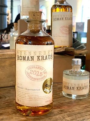 Fľaše z liehovaru Roman Kraus na drevenom stole.