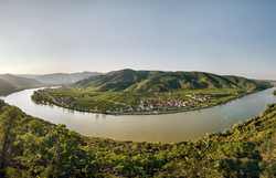 Die sanften Hügel des Dunkelsteinerwaldes umarmen die Donau, während die goldenen Strahlen der Abendsonne die Landschaft in ein warmes Licht tauchen. Hier, wo die Natur in voller Pracht erblüht, laden die malerischen Weinberge und charmanten Dörfer zu unvergesslichen Erlebnissen ein.
