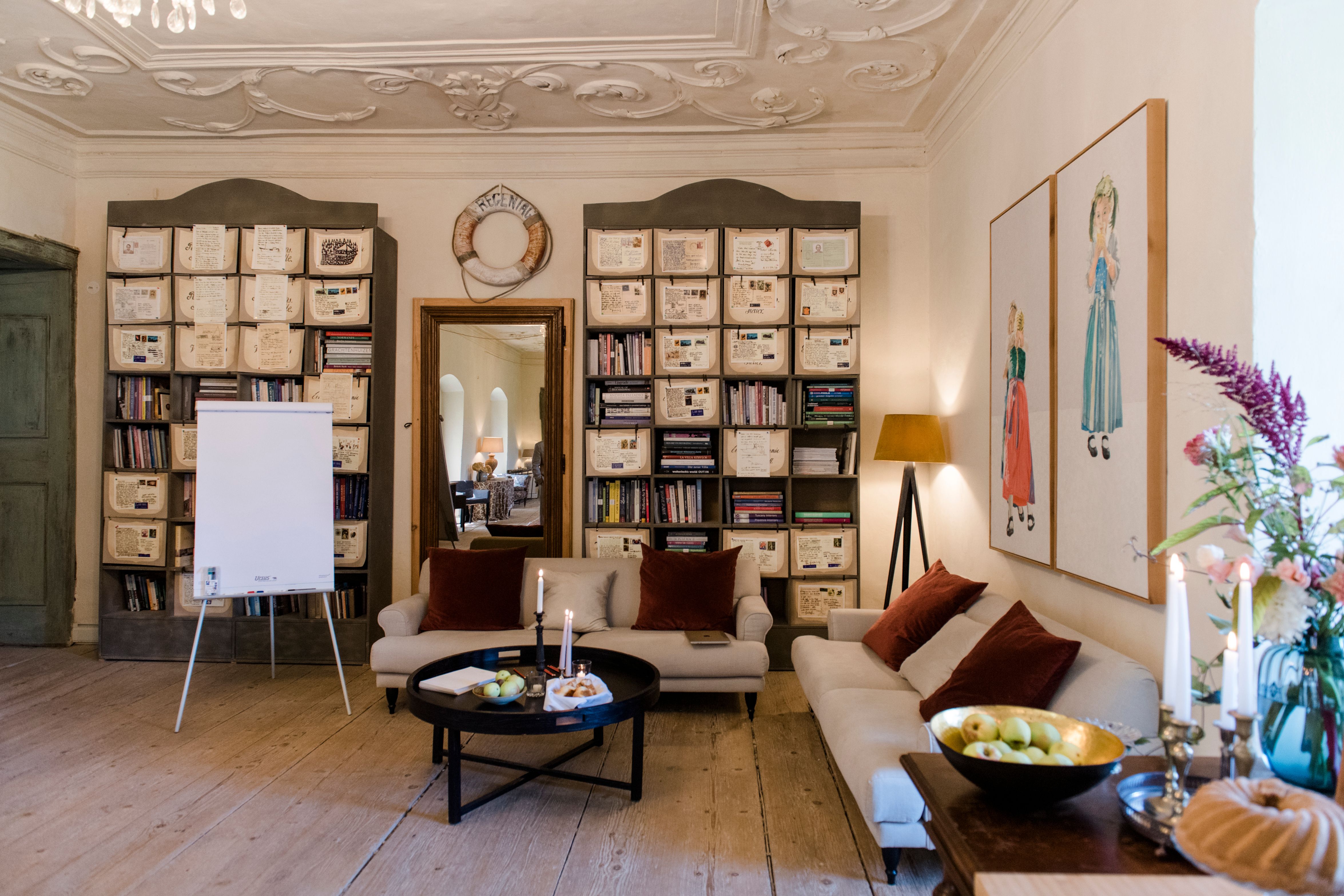 Útulná izba s pohovkami, policami na knihy a dekoráciami.