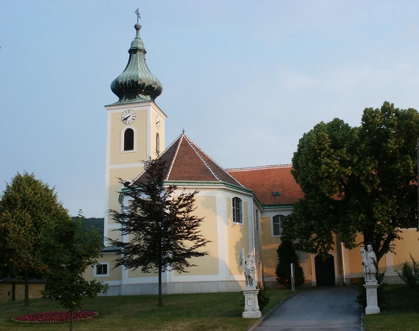 Pútnický kostol Wolfsthal s vežou a sochami v popredí.