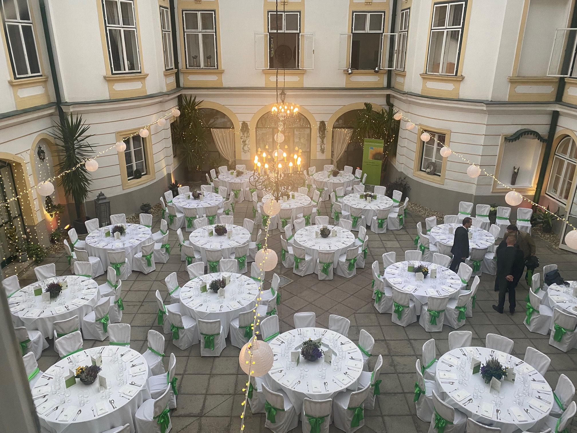 Vnútorné nádvorie s okrúhlymi bielymi stolmi a kreslami