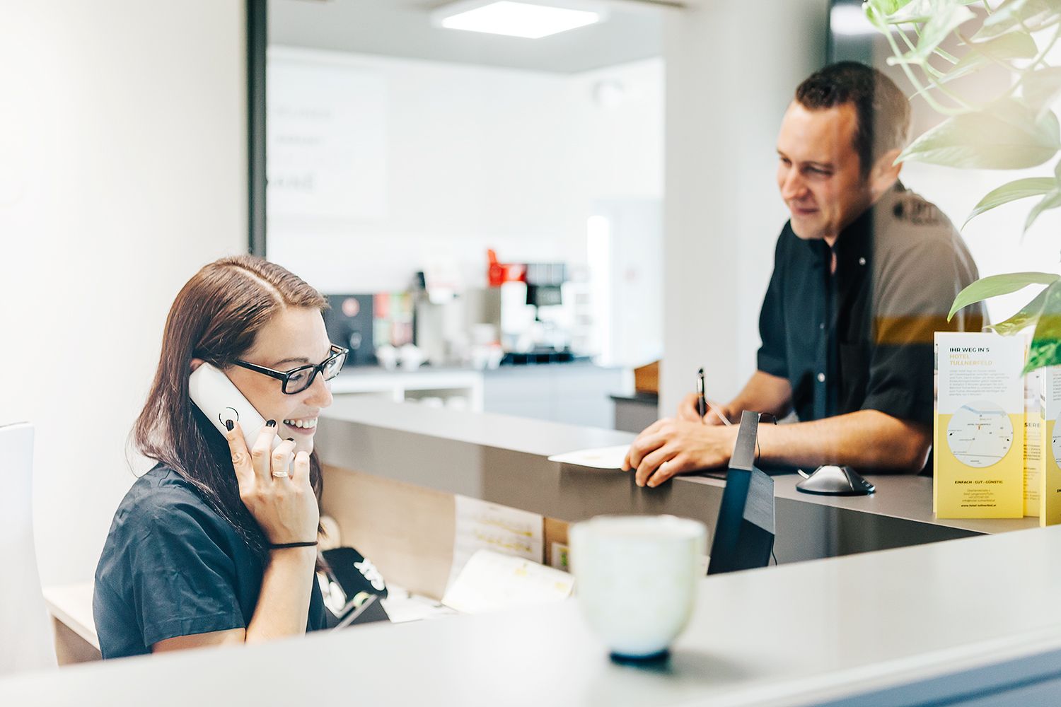 Recepčná telefonuje s hosťom na recepcii.