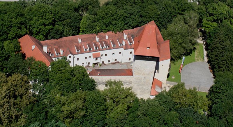 Letecký pohľad na hrad Ulmerfeld obklopený stromami.