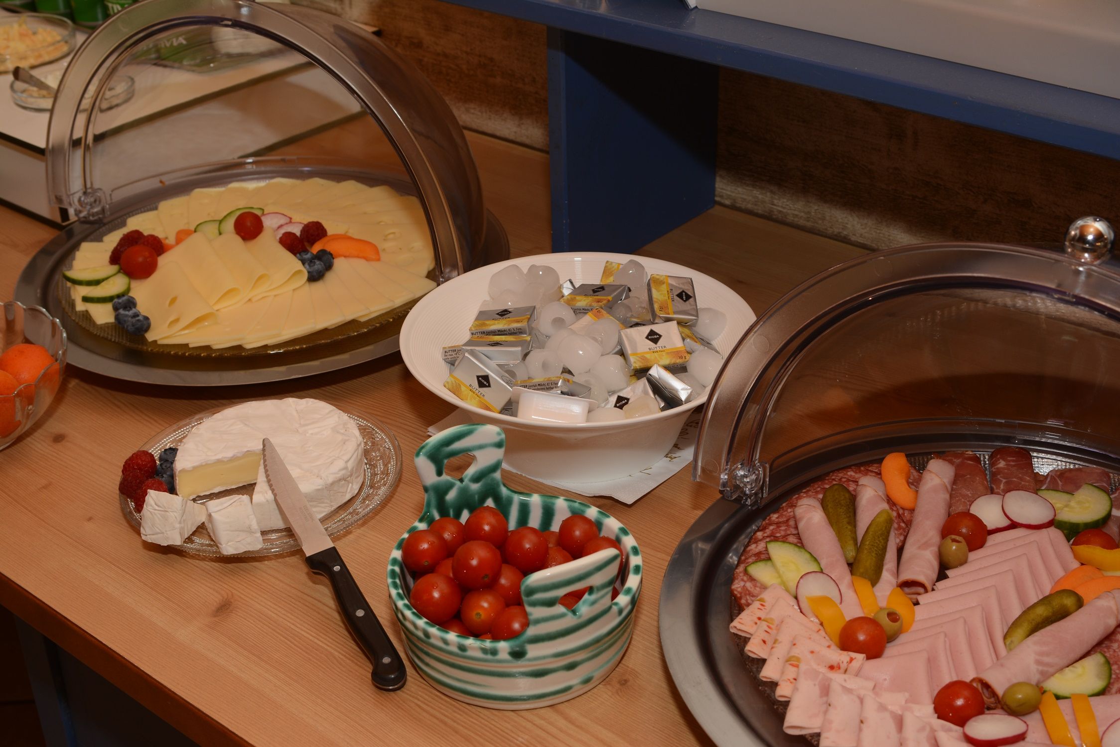 Raňajkový bufet so syrom, klobásou, paradajkami, maslom a camembertom.