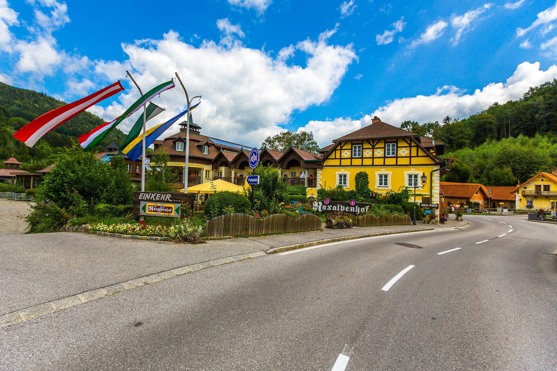 Raxalpenhof sa nachádza priamo na miestnej komunikácii, pred domom je modrá fontána, balkóny a celú prednú časť domu lemujú kvety a kríky.