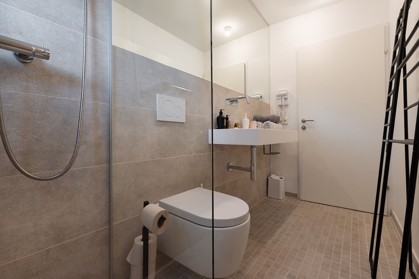 Moderná kúpeľňa so skleneným sprchovacím kútom, umývadlom a WC.