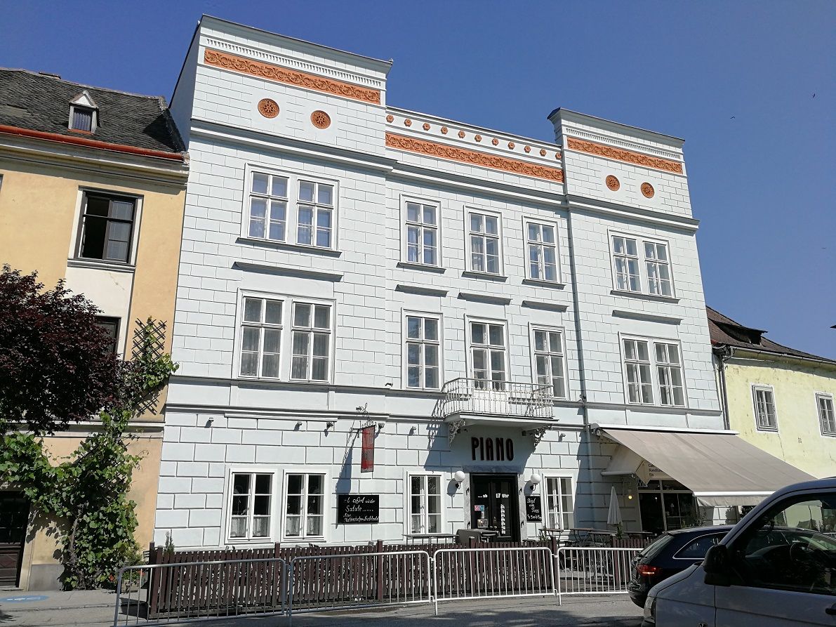 Pohľad zvonka na historickú budovu s označením "Piano" v Kremse.