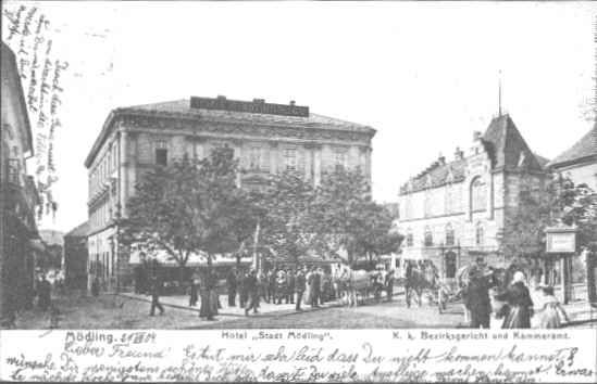 Historický pohľad na hotel Stadt Mödling s ľuďmi a kočmi na ulici.