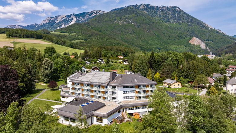 Letecký pohľad na veľký hotel v zelenej hornatej krajine.