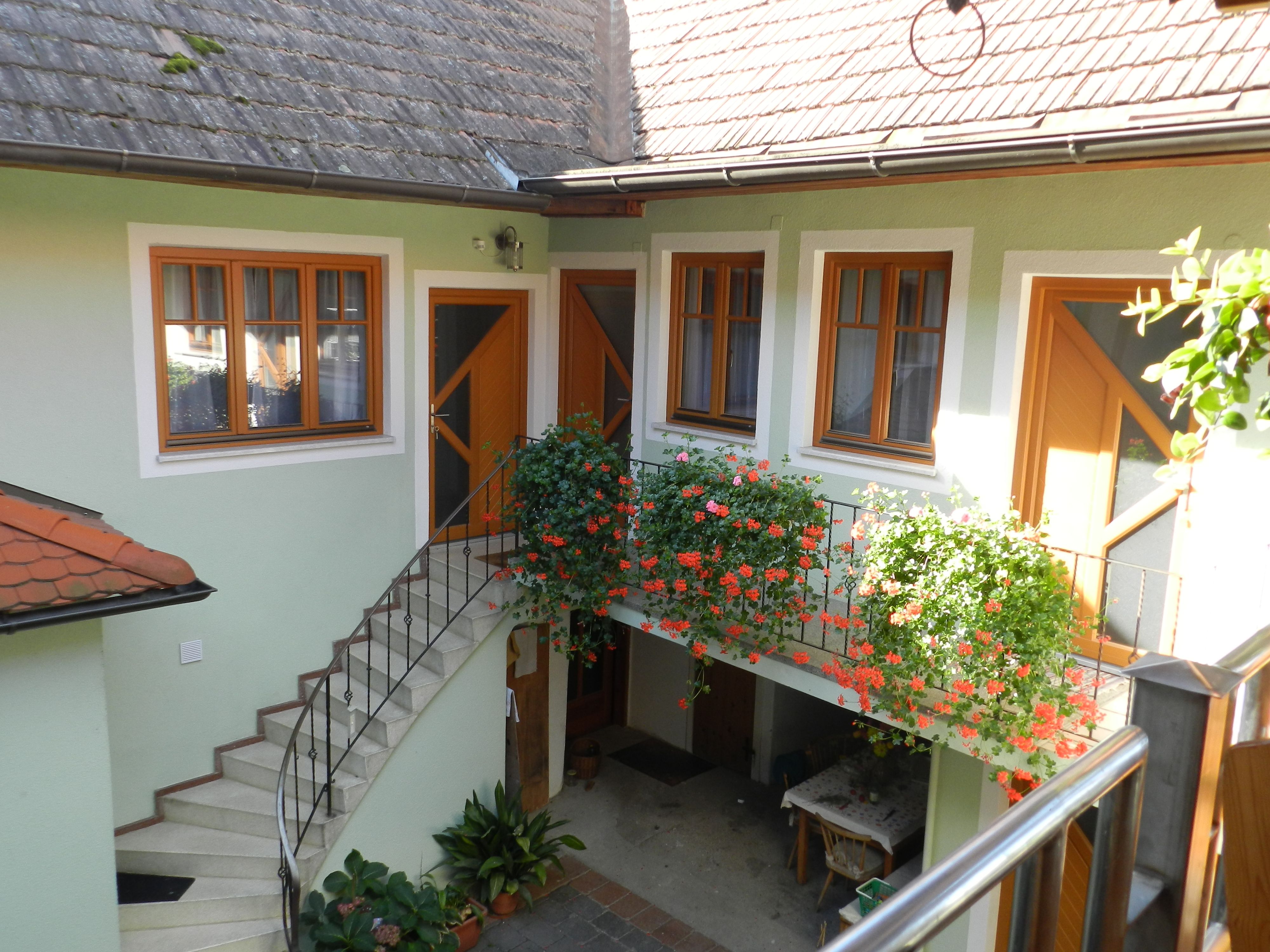 Vnútorný dvor so schodmi, kvetmi a stolom.