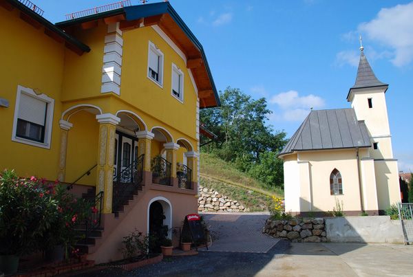 Žltá budova so schodmi a malým kostolom vedľa nej.