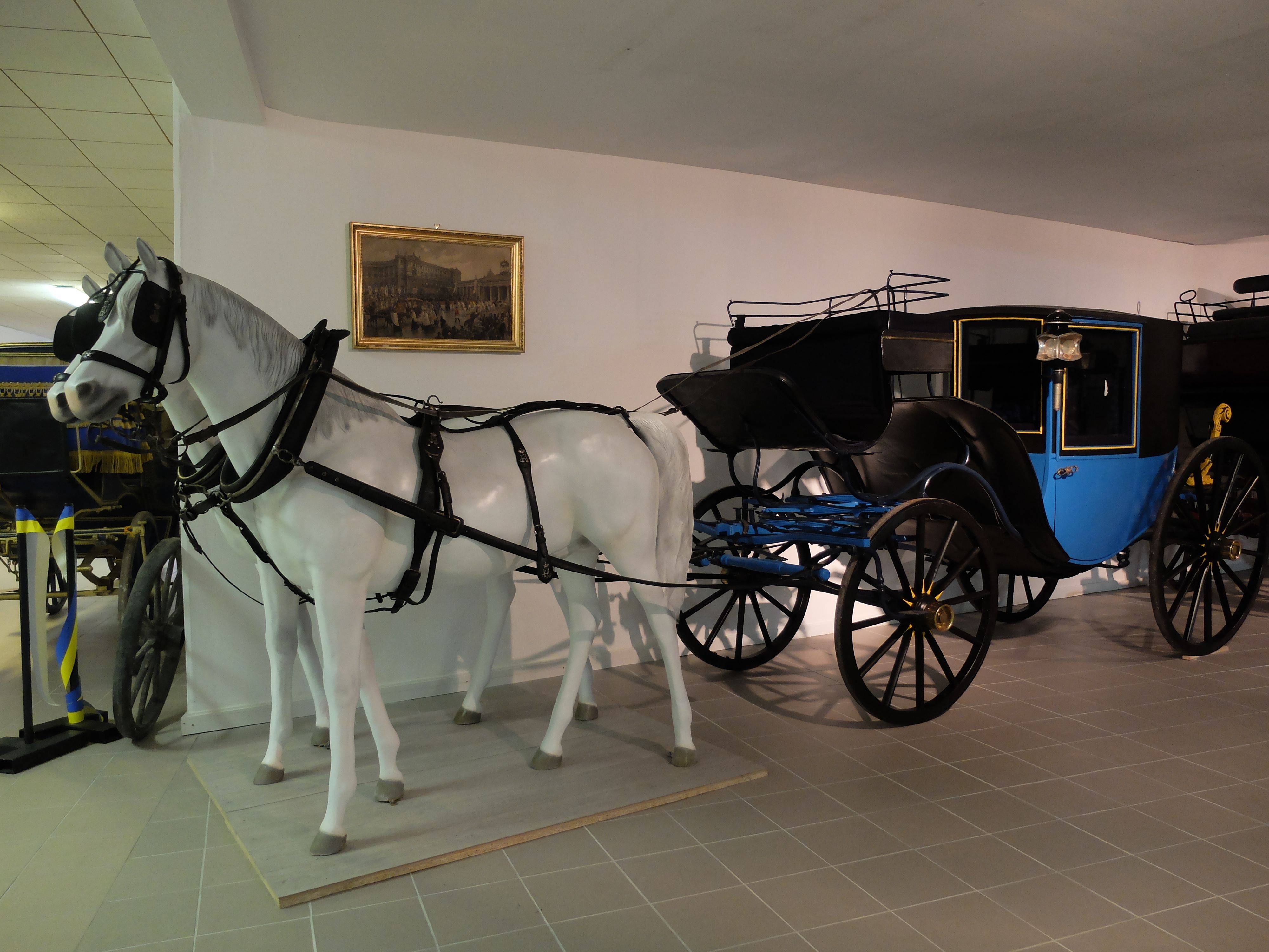 Historický koč s modelom bieleho koňa v múzeu.