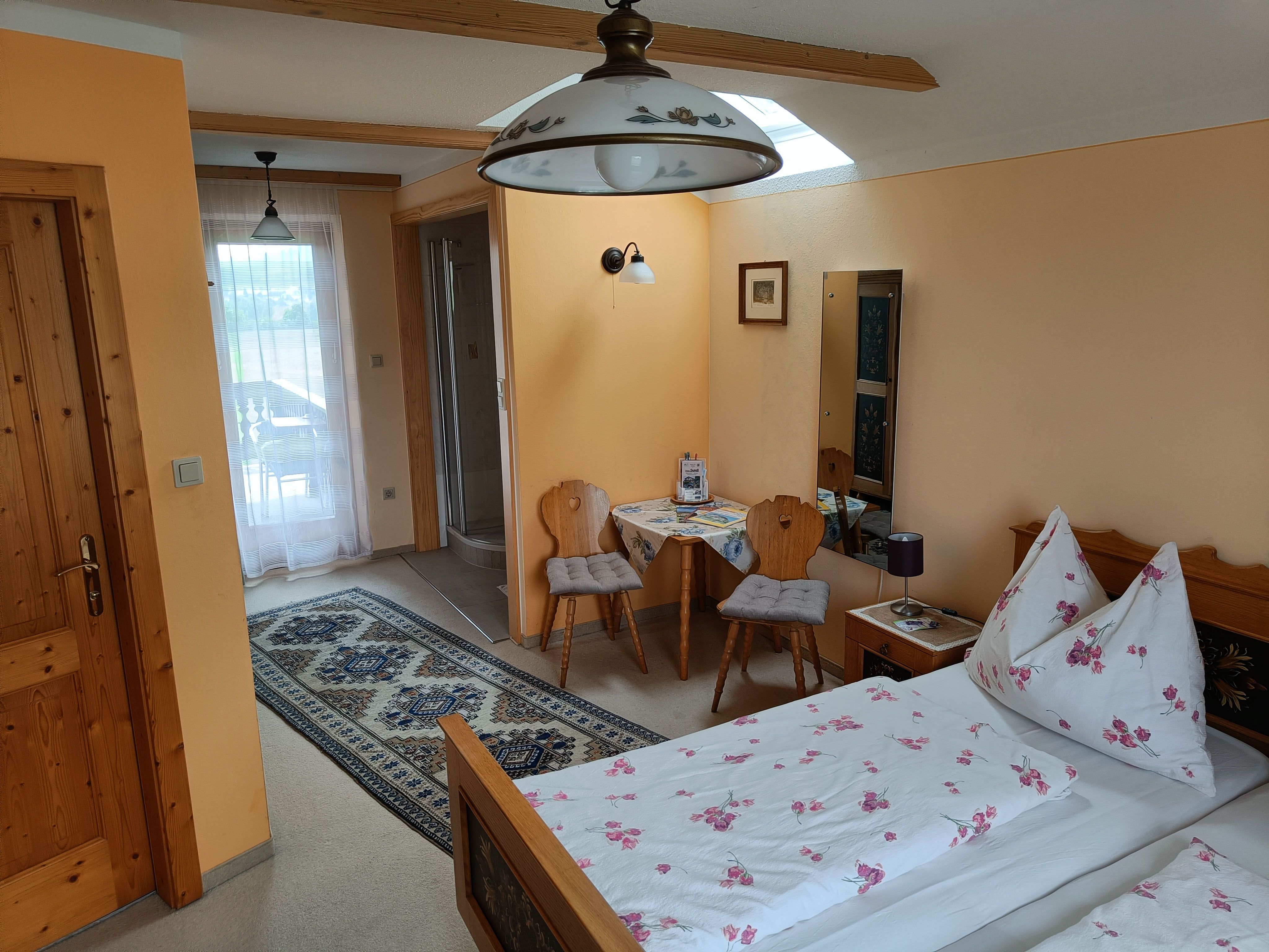 Izba s posteľou, stolom a 2 stoličkami