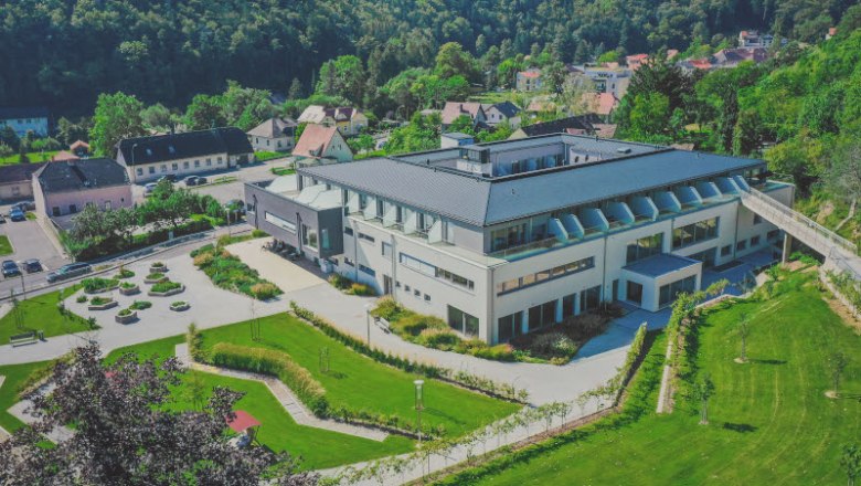 Leteck&yacute; pohľad na modern&uacute; budovu so z&aacute;hradou a okolitou krajinou.