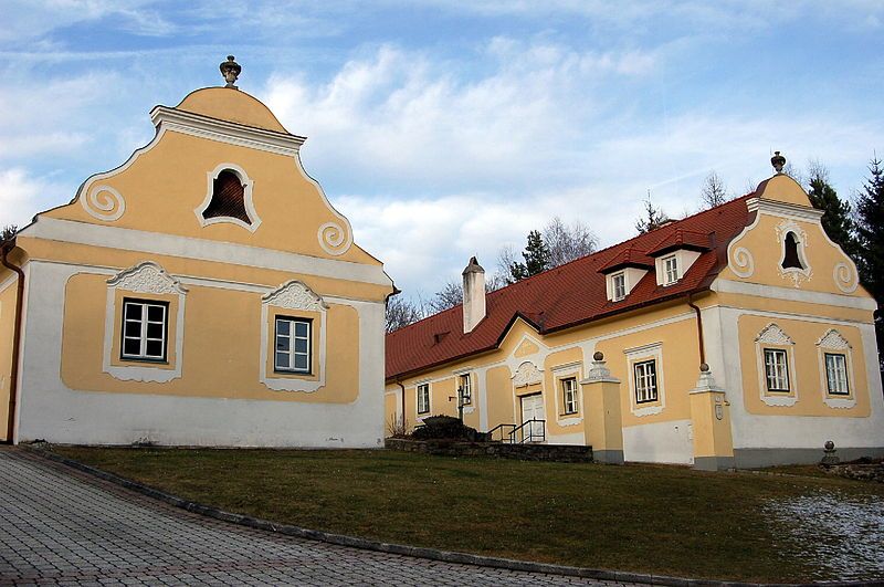 Historická fara v Krumbachu so žltými fasádami a červenými strechami.