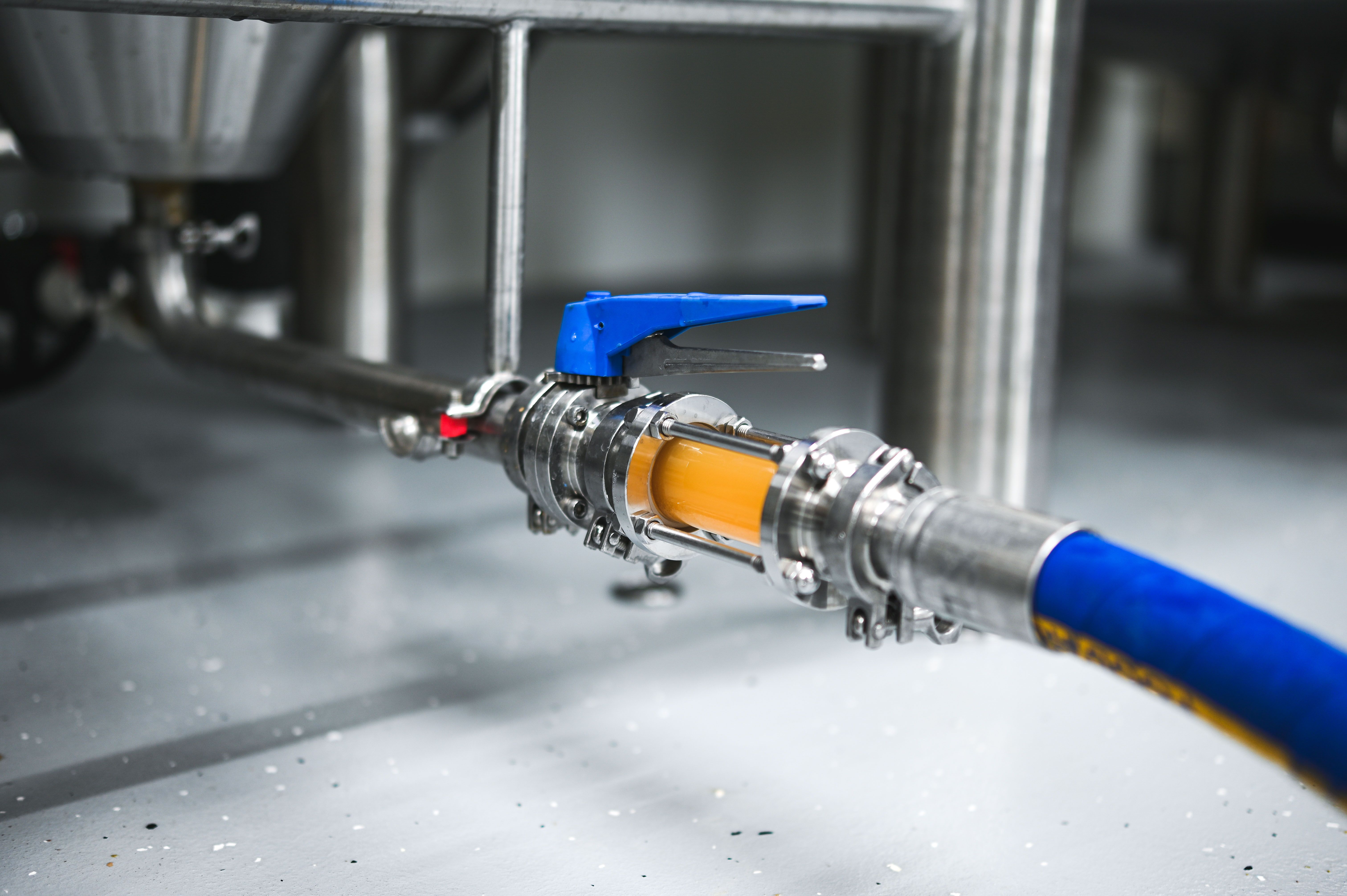 Detailný záber pivovarskej hadice s ventilom a pretekajúcou tekutinou.