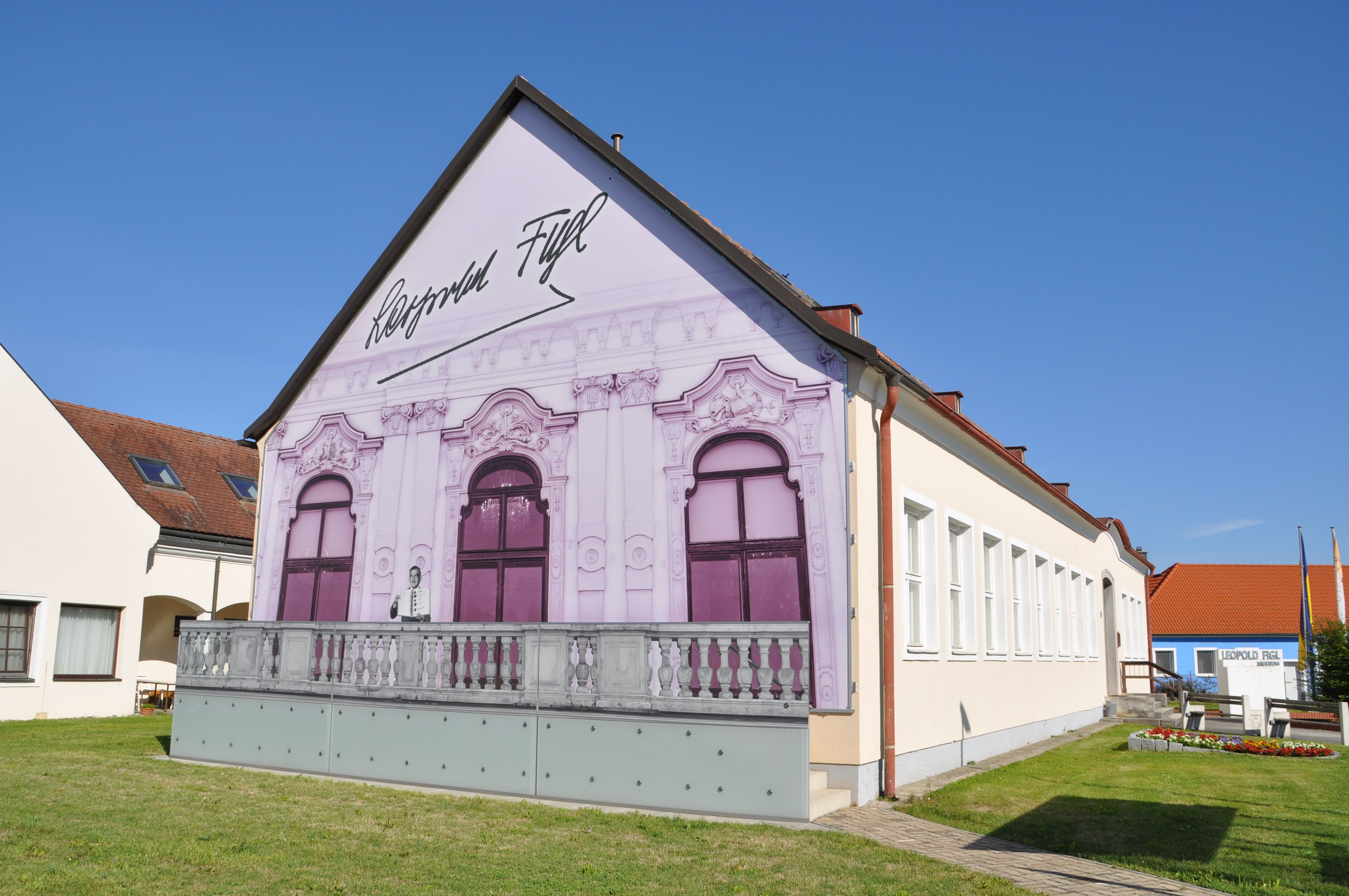 Leopold Figl Museum mit bemalter Fassade und blauen Himmel.