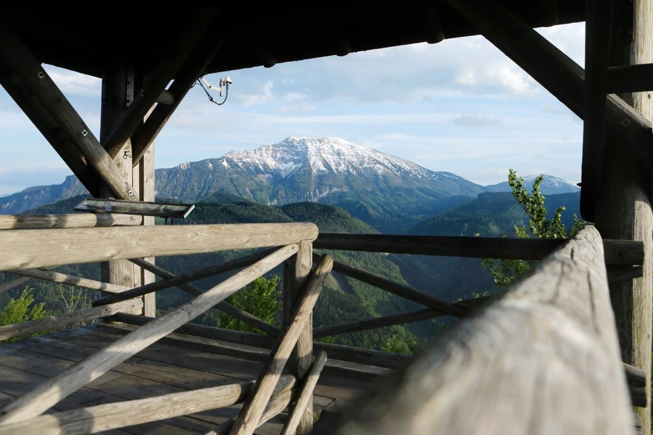 Drevená rozhľadňa s výhľadom na zasnežené hory a zalesnené kopce.