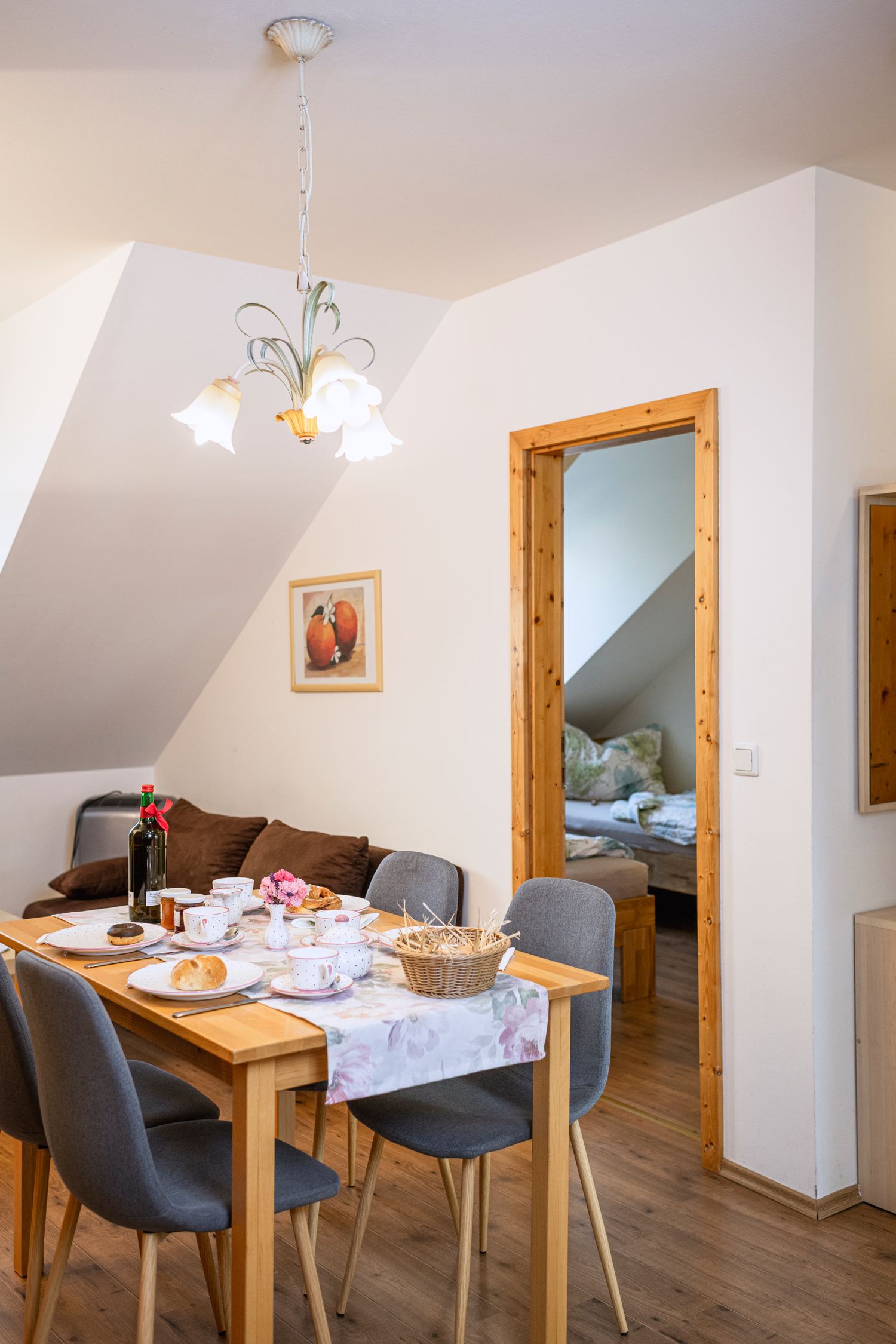 Jedálenský kút v prázdninovom byte s prestretým stolom a výhľadom do spálne.
