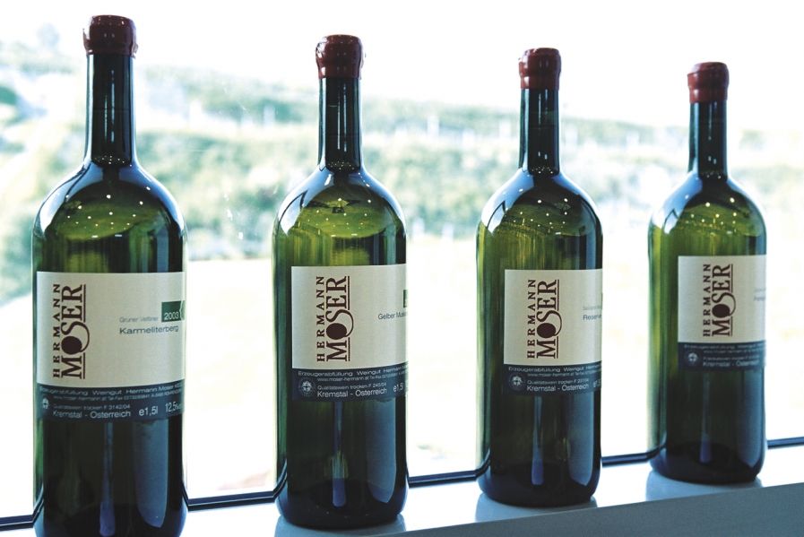 Štyri fľaše vína z vinárstva Hermann Moser na parapete.
