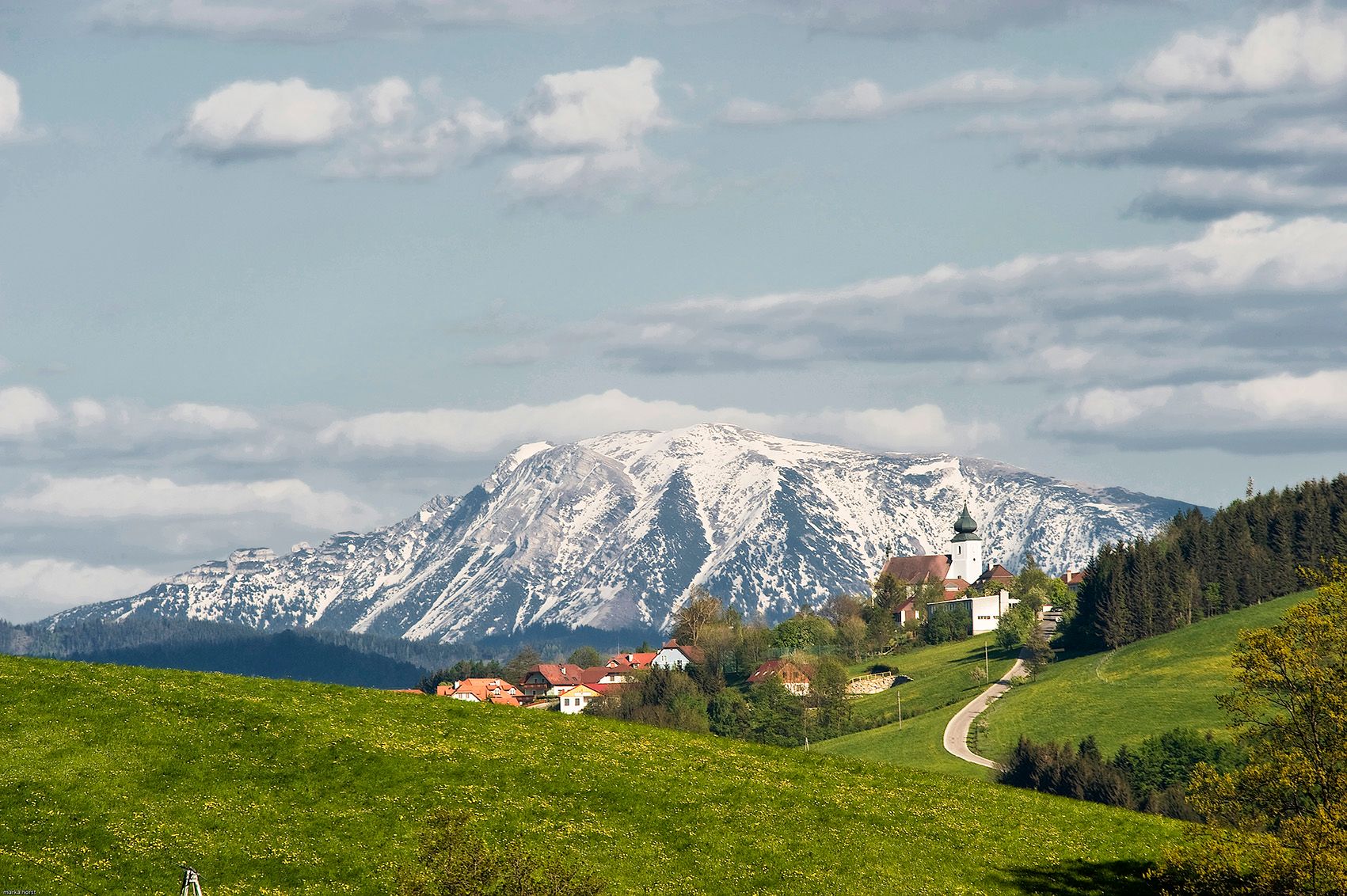 Pohľad na St. Leonhard am Walde so zasneženou horou v pozadí.