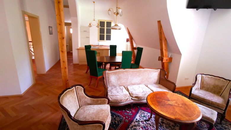 Ob&yacute;vacia izba so starožitn&yacute;m n&aacute;bytkom a dreven&yacute;mi tr&aacute;mami.