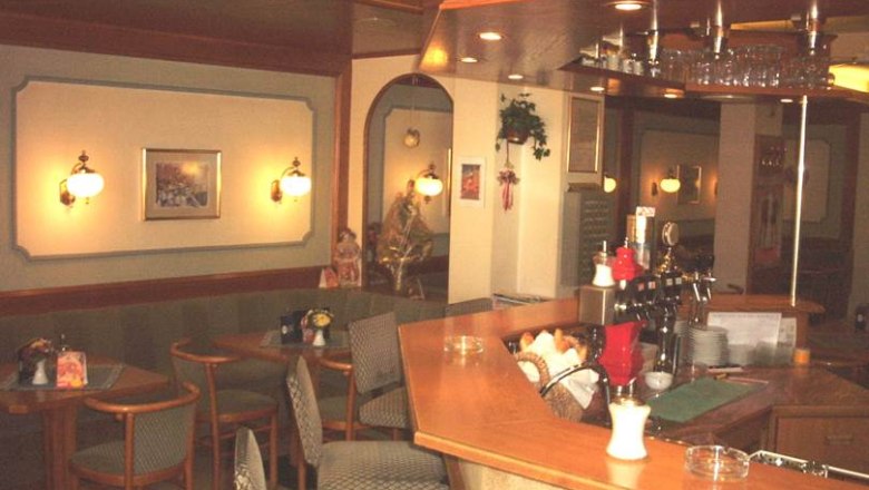 Pohľad do interi&eacute;ru &uacute;tulnej kaviarne s dreven&yacute;mi pultmi a miestami na sedenie.