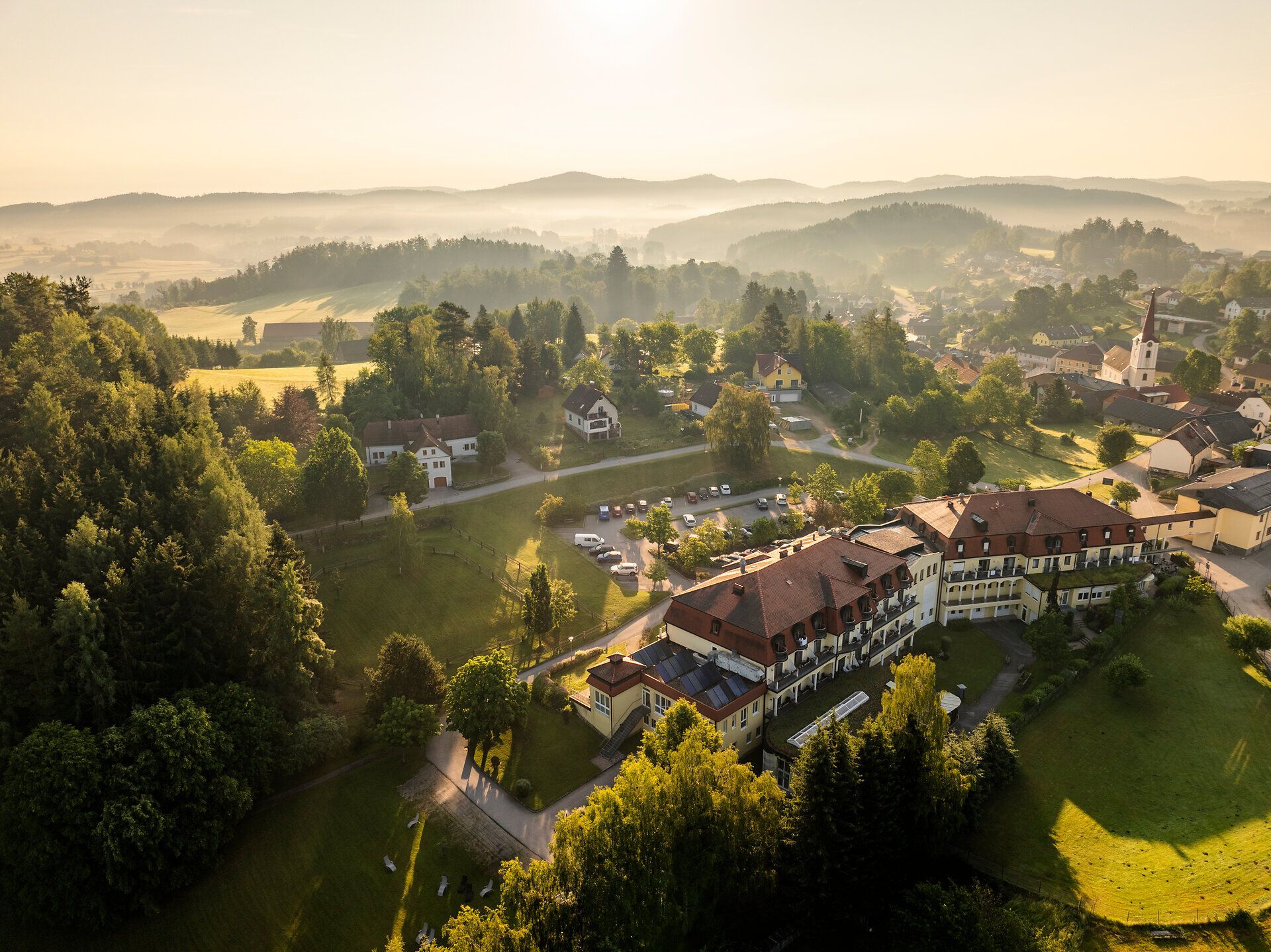 Letecký pohľad na kúpeľné stredisko Bad Großpertholz vo Waldvierteli s okolitou obcou, lúkami a zalesnenými kopcami.