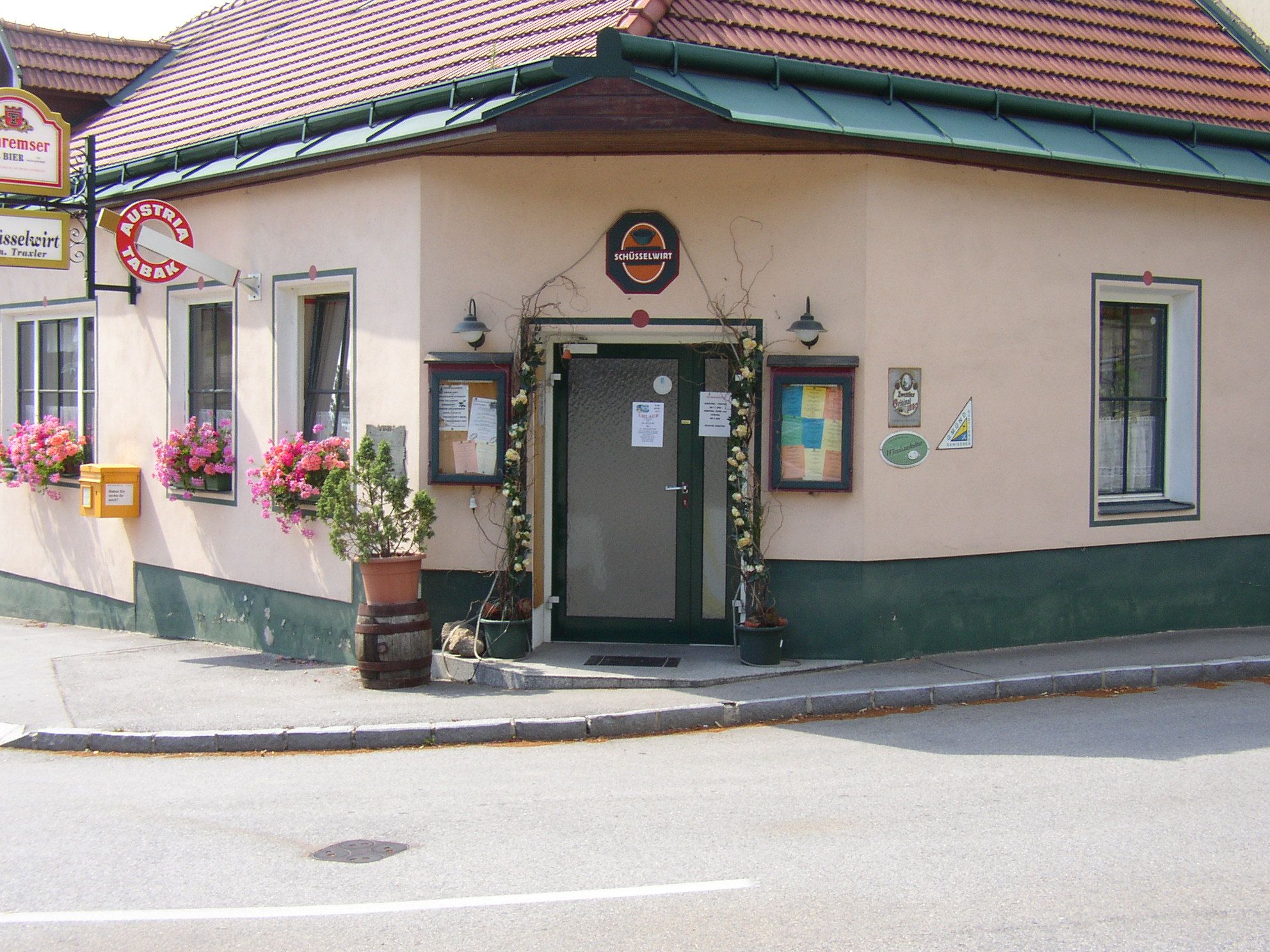 Vchod do tradičného hostinca s kvetmi a nápismi.