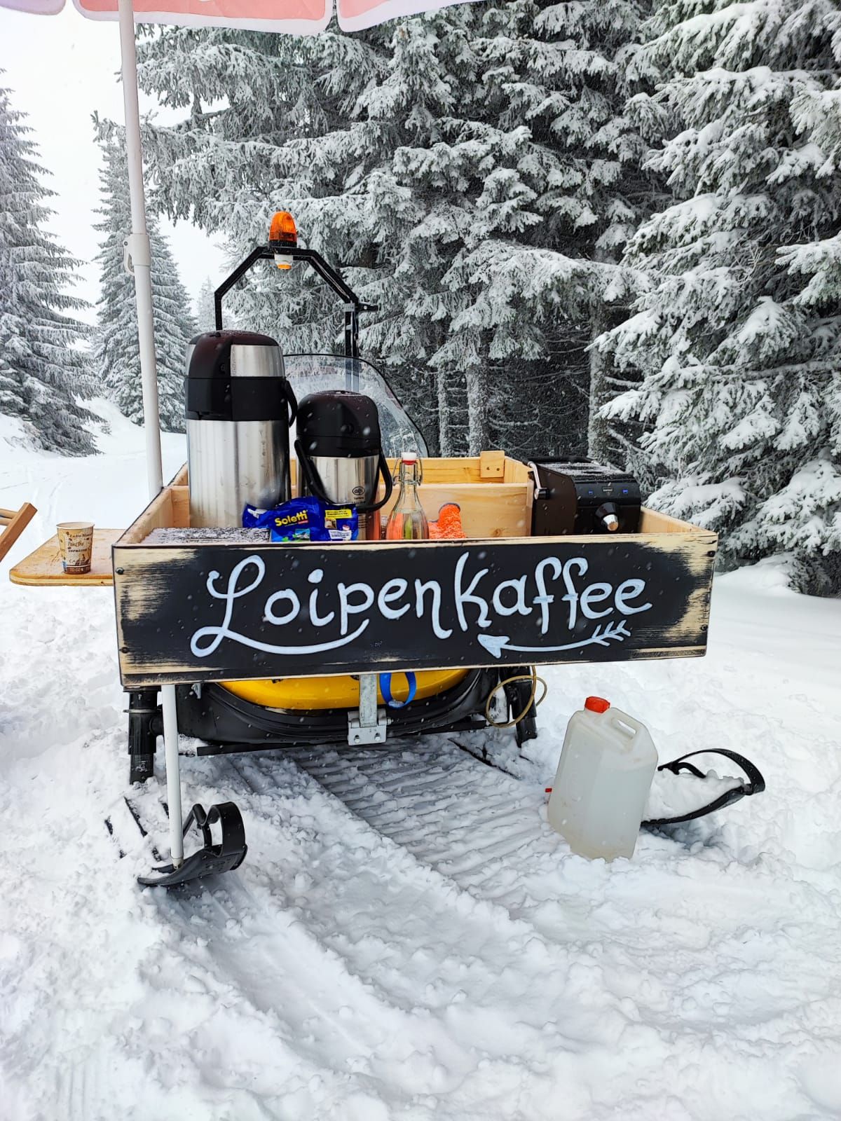 Mobilný stánok s kávou na snehu s označením "Loipenkaffee".
