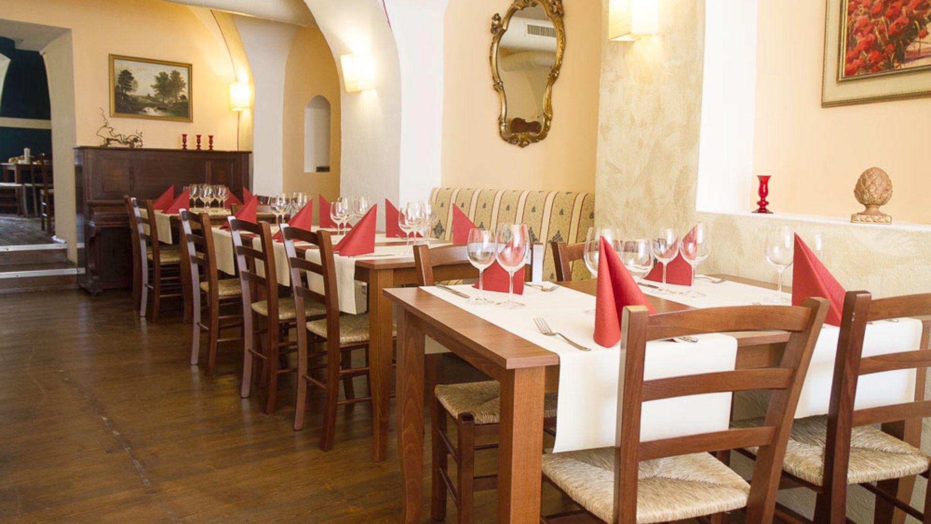 Elegantná reštaurácia s prestretými stolmi a červenými obrúskami.