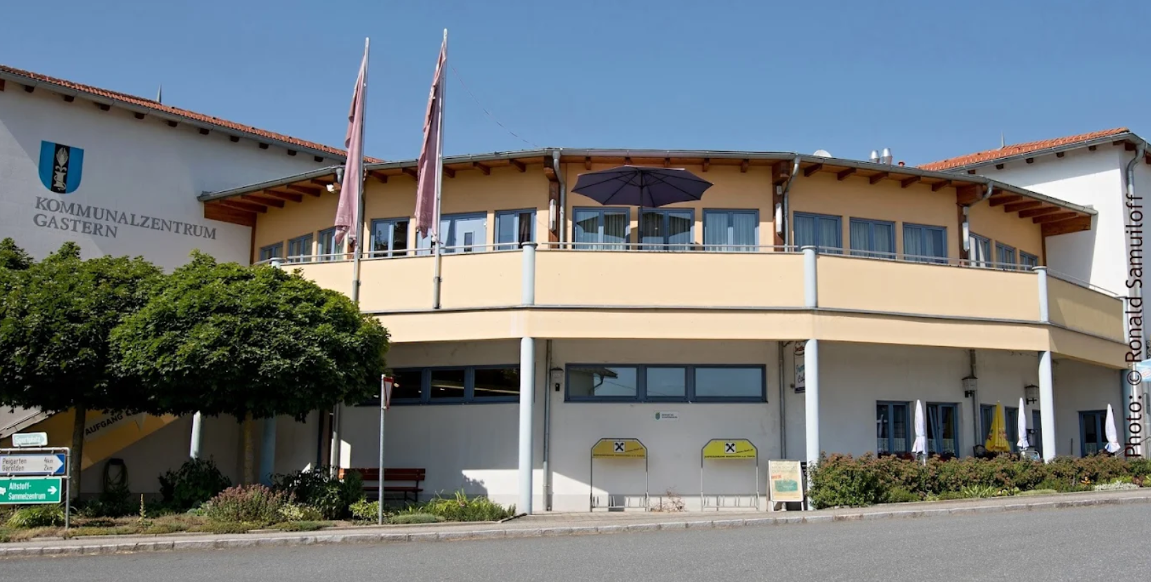 Exteriérový pohľad na komunitné centrum Gastern s modrými oknami a žltou fasádou.