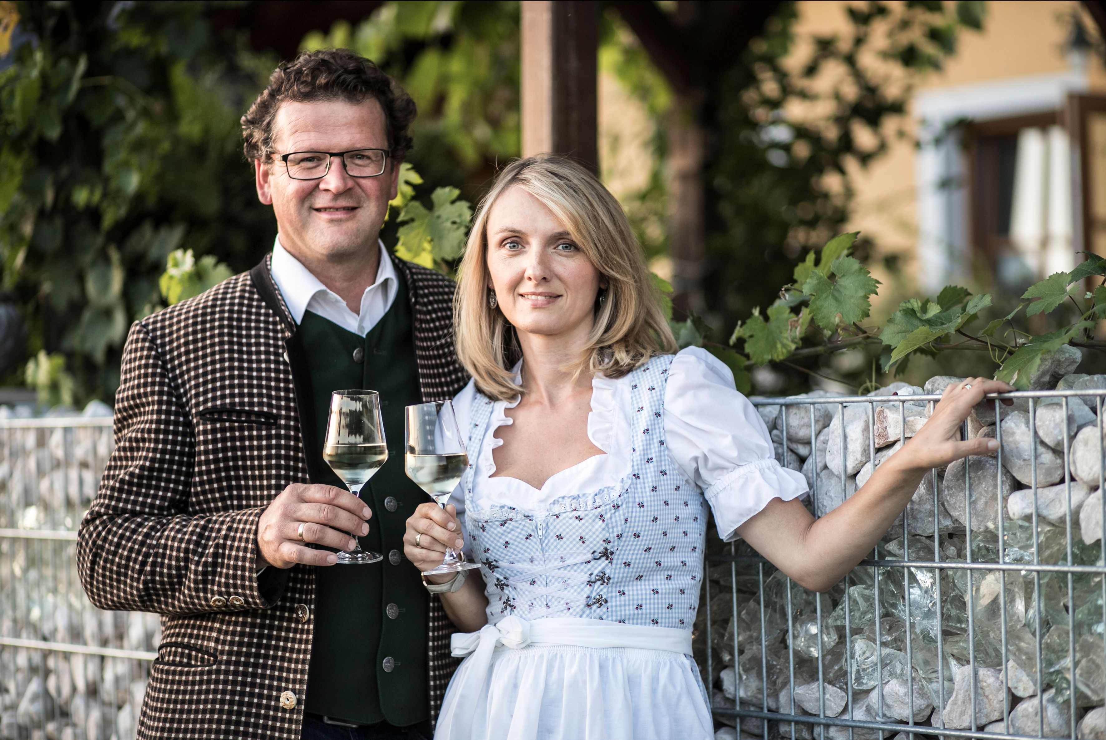 Muž a žena v tradičnom odeve držia poháre na víno.